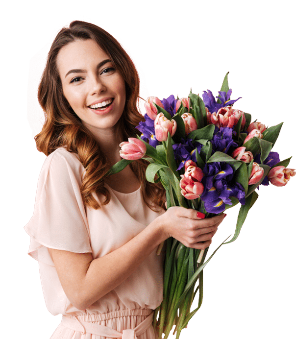 Smiling woman holding a bouquet of pink tulips and purple flowers.