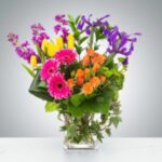 Bright mixed flower bouquet in a clear glass vase.