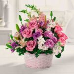 Elegant bouquet of pink and purple flowers in a woven basket.