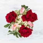 A bouquet with red roses and pink flowers on a white background.