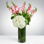 Elegant pink and white floral arrangement in a clear vase.