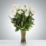 Elegant bouquet of white roses in a clear glass vase.