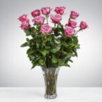 A bouquet of pink roses in a clear glass vase.