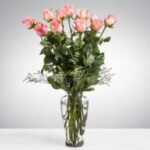 A bouquet of pink roses in a clear glass vase.