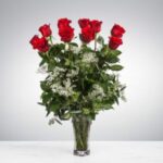 A bouquet of red roses in a clear glass vase.