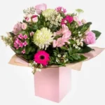 Elegant bouquet of mixed pink and white flowers in a pastel pink box.