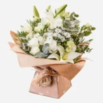 Elegant bouquet of white flowers wrapped in rustic paper.