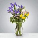 A colorful bouquet of mixed flowers in a clear glass vase.