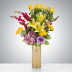Elegant bouquet of mixed flowers in a gold vase.