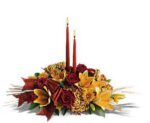 Elegant floral centerpiece with two tall red candles.