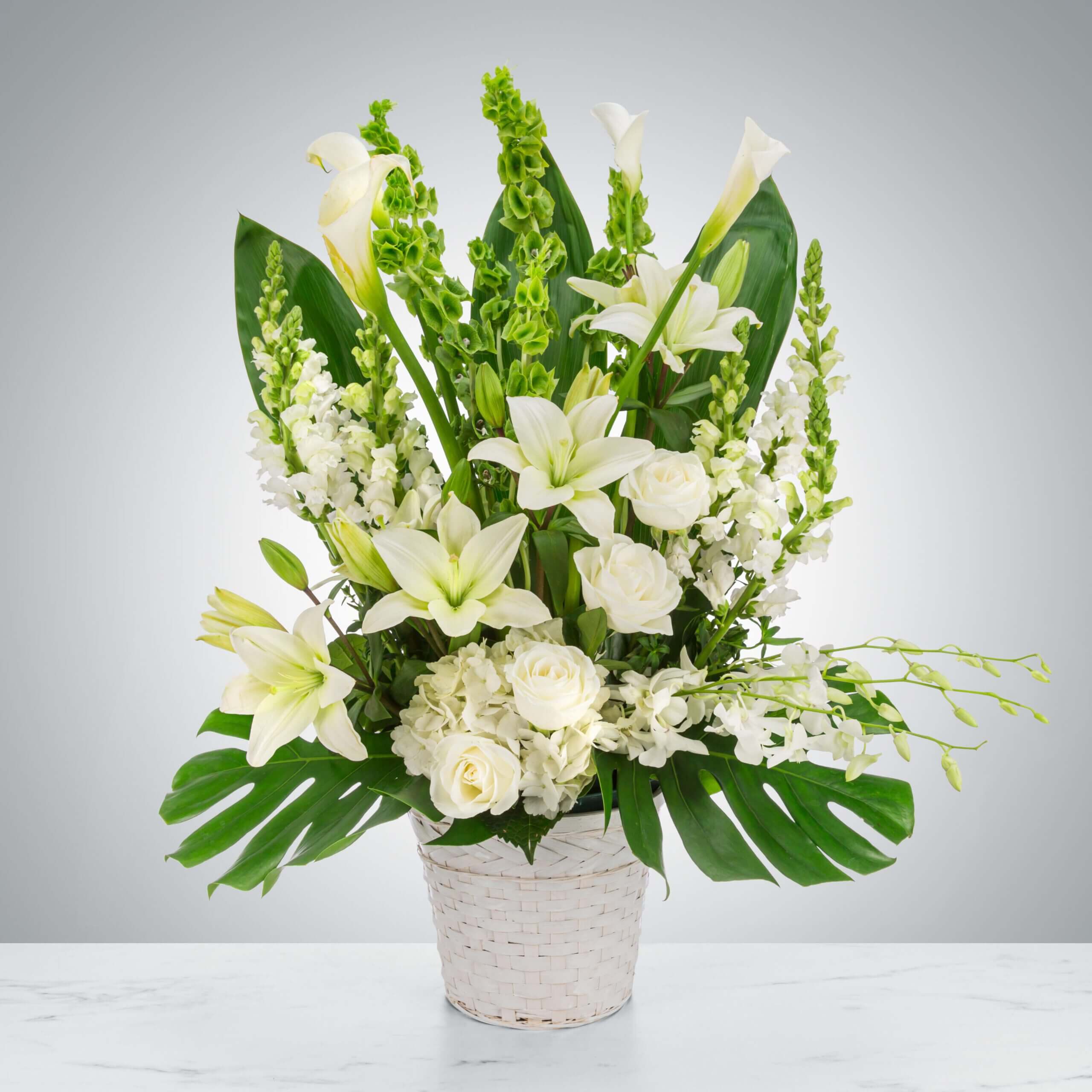 Elegant white floral arrangement in a textured white vase. Elegant white floral arrangement in a textured white vase.