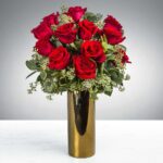 A bouquet of red roses in a tall golden vase.