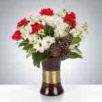 Elegant bouquet with red and white flowers in a dark vase.