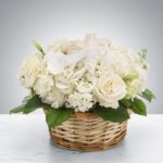 Elegant white flower arrangement in a woven basket.