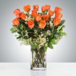 A bouquet of vibrant orange roses in a clear glass vase.