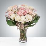 Elegant bouquet of pink and white roses in a glass vase.