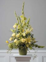 Elegant yellow floral arrangement in a green vase.