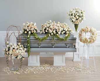 Elegant white floral arrangements adorning a modern silver casket.