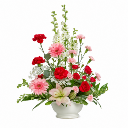 A vibrant bouquet of red carnations, pink gerbera daisies, and white lilies with greenery.