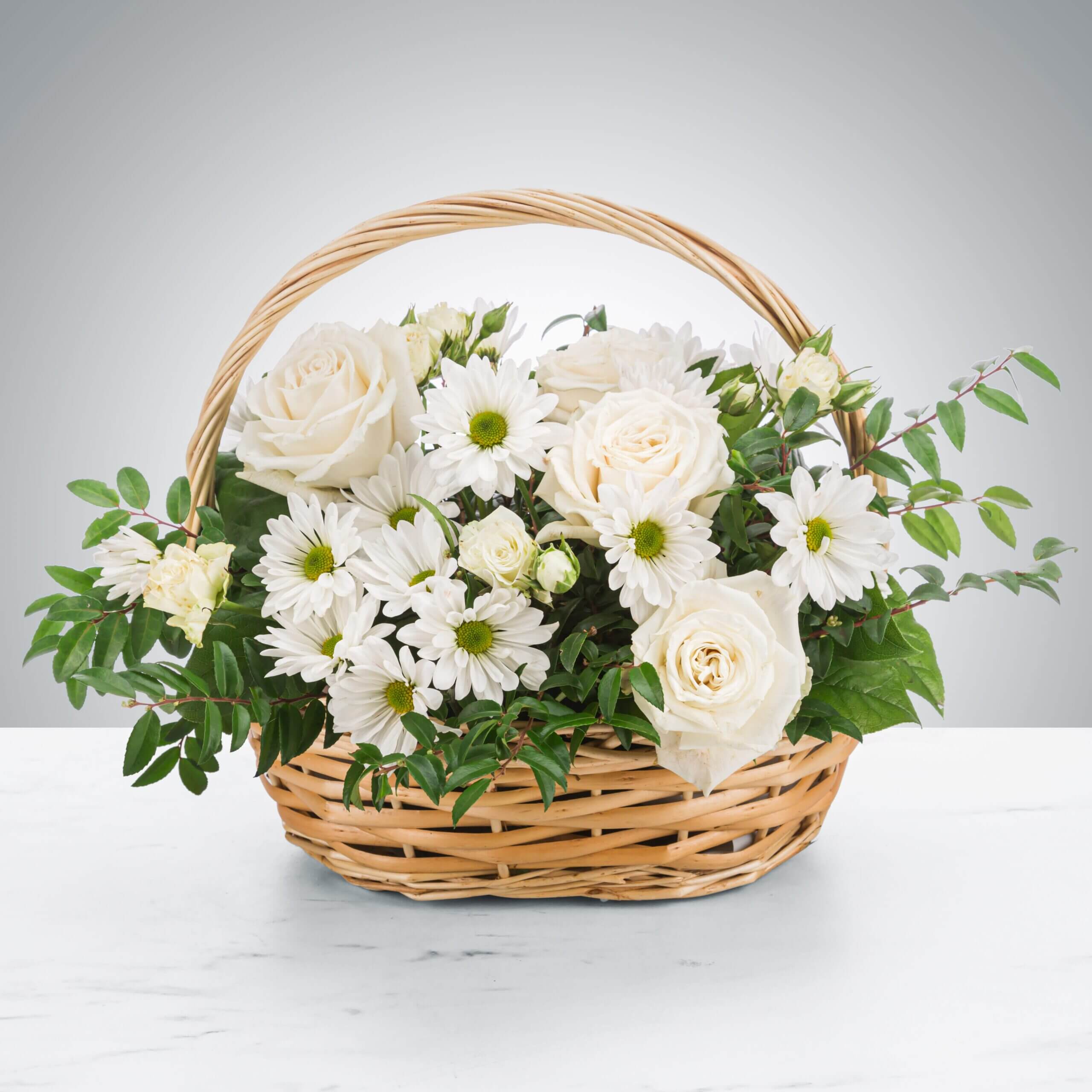A basket filled with white flowers and greenery. A basket filled with white flowers and greenery.