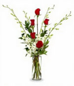 Elegant bouquet with red roses and white flowers in a glass vase.