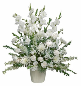 A tall, elegant all-white floral arrangement in a neutral ribbed ceramic pot, featuring gladiolus, spider mums, and carnations with lush green foliage.