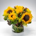 Bright sunflower bouquet in a clear glass vase.