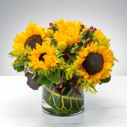 Bright sunflower bouquet in a clear glass vase.
