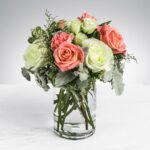 A delicate bouquet of pink and white roses in a glass vase.