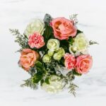 A delicate bouquet of pink and white flowers with greenery.