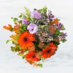 Bright bouquet with orange, purple, and pink flowers.