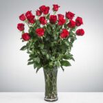 A bouquet of fresh red roses in a clear glass vase.