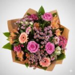 Vibrant mixed flower bouquet in a beige box.