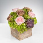 Elegant floral arrangement in a rustic wooden cube.