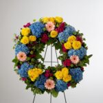Colorful floral wreath with roses, carnations, and hydrangeas.