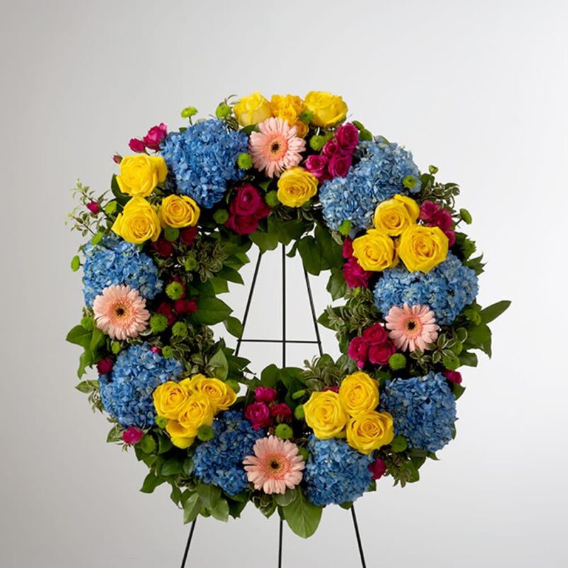 Colorful floral wreath with roses, carnations, and hydrangeas.