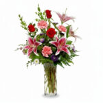 Elegant bouquet of red and pink flowers in a clear vase.