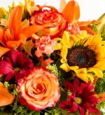 A vibrant bouquet featuring roses, sunflowers, and other colorful flowers.