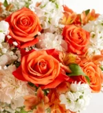 A vibrant bouquet of orange roses and white flowers.