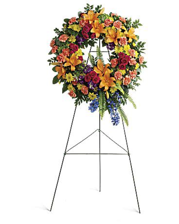 Colorful floral wreath on a metal stand.