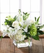 Elegant white and green floral arrangement in a clear glass vase.