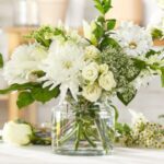 Elegant white flower arrangement in glass jars.