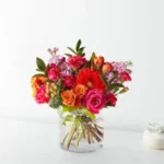 Vibrant mixed flower bouquet in a clear glass vase.