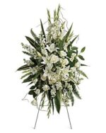 Elegant white floral funeral spray with lilies and greenery.