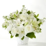 Elegant bouquet of white flowers in a clear vase.