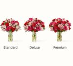 Three glass vases filled with the "You're Precious" flower bouquet in Standard, Deluxe, and Premium sizes, featuring red and pink roses, carnations, and alstroemeria.