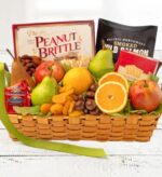 A deluxe kosher gift basket overflowing with fresh fruits like apples, pears, and oranges, alongside gourmet treats including peanut brittle, smoked salmon, dark chocolate, and crackers.